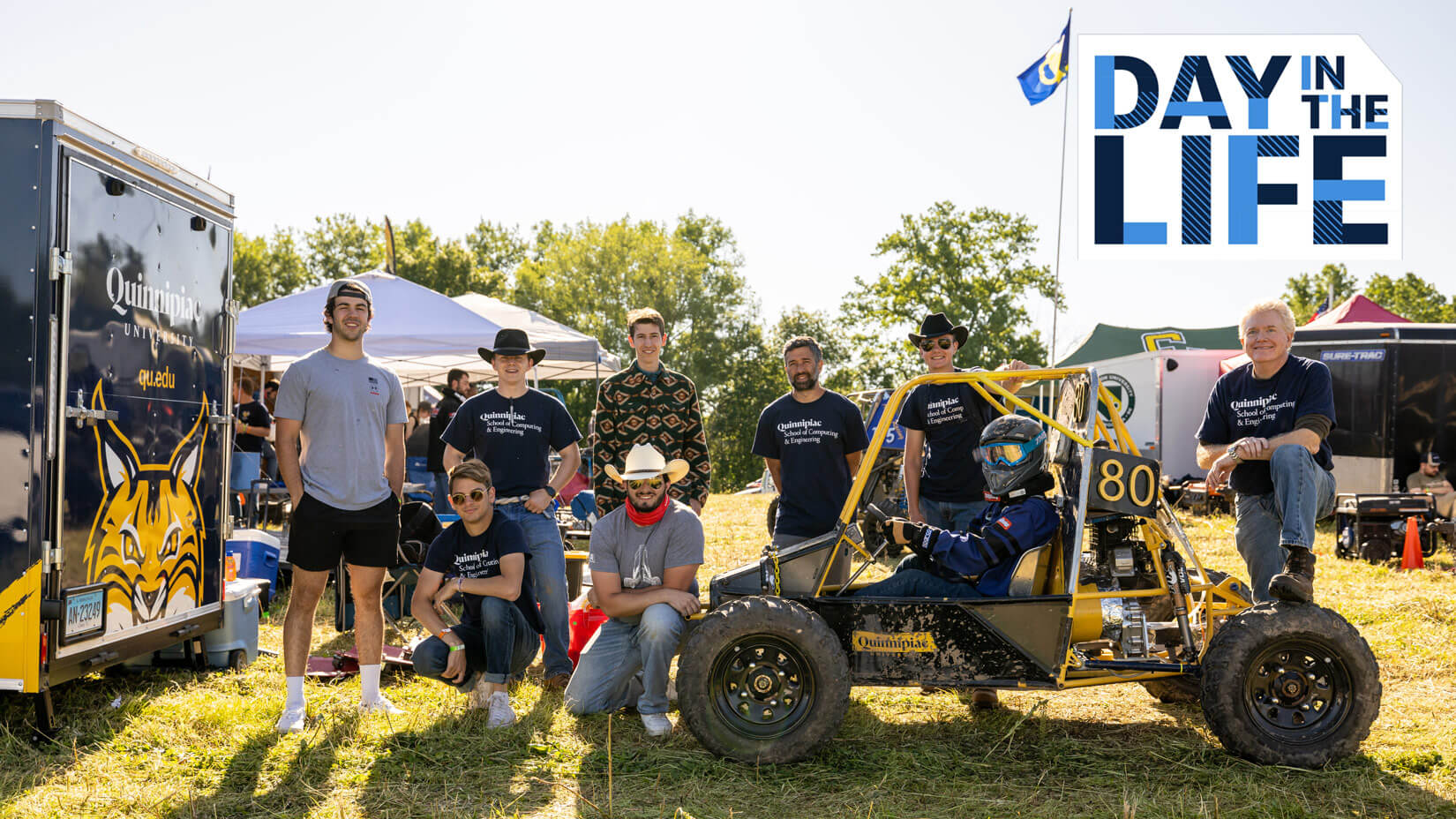 Students posing with the Baja vehicle, plays video
