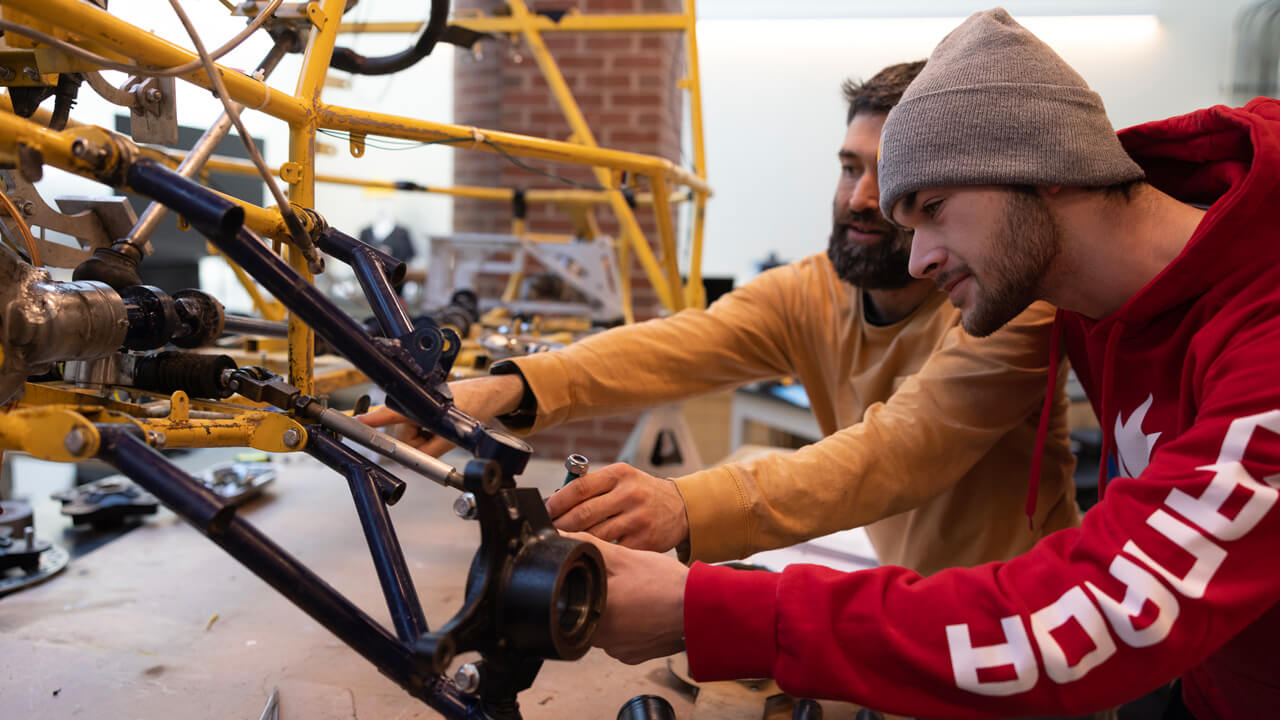 2 students examine the vehicle